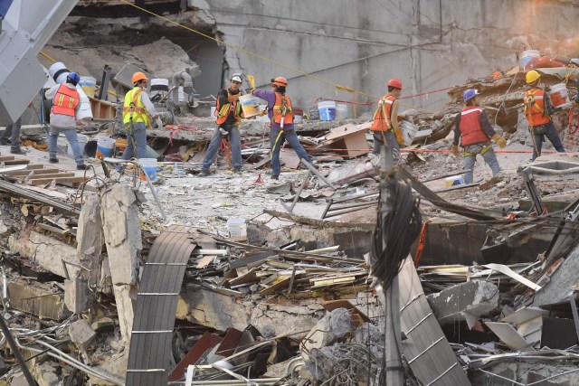 Rescue workers continue to dig into the debris of a flattened building in the search for survivors in Mexico City on September 24, 2017, five days after the powerful quake that hit central Mexico. A strong 6.1 magnitude quake shook Mexico on Saturday, causing panic in traumatized Mexico City, where rescuers trying to free people trapped from this week's earlier earthquake had to temporarily suspend work. / AFP PHOTO / Omar Torres