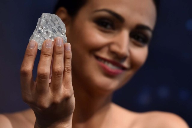 (FILES) This file photo taken on June 14, 2016 shows a model posing with an uncut 1109-carat diamond named 'Lesedi La Rona' at Sotheby's auction house in London. Graff diamonds have purchased the Lesedi La Rona diamond on September 26, 2017 for $53 million from the Canadian mining company Lucara Diamond. / AFP PHOTO / BEN STANSALL