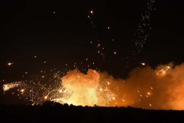 This photo taken on September 27, 2017 near Kalynivka shows explosions at a military munitions depot. Ukranian authorities evacuated nearly 30,000 people September 27 from the central Vinnytsya region after a huge munitions depot caught fire and set off artillery shells and blasts prosecutors were treating as an act of "sabotage". It was the second major incident affecting a Ukrainian weapons storage site this year. Kiev blamed the first one in March on Moscow and its Russian-backed insurgents fighting Ukrainian forces in the war-wrecked east -- a charge both sides denied. / AFP PHOTO / Sergei SUPINSKY