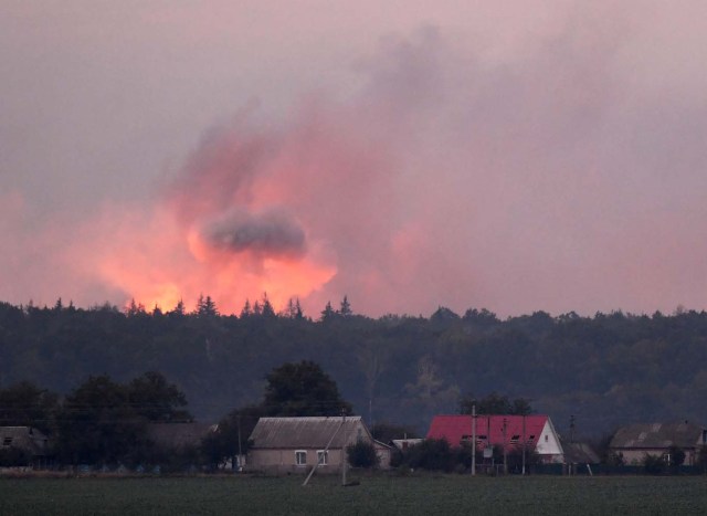 This photo taken on September 27, 2017 near Kalynivka shows explosions at a military munitions depot. Ukranian authorities evacuated nearly 30,000 people September 27 from the central Vinnytsya region after a huge munitions depot caught fire and set off artillery shells and blasts prosecutors were treating as an act of "sabotage". It was the second major incident affecting a Ukrainian weapons storage site this year. Kiev blamed the first one in March on Moscow and its Russian-backed insurgents fighting Ukrainian forces in the war-wrecked east -- a charge both sides denied. / AFP PHOTO / Sergei SUPINSKY