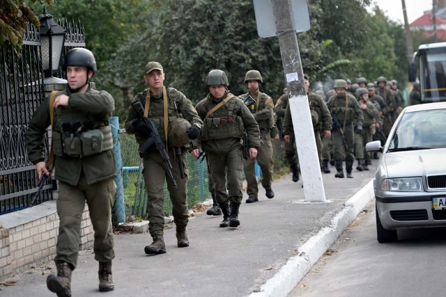 National guard servicemen patrol the streets after the evacuation of the town of Kalynivka following explosions at a nearby arms depot on September 27, 2017. Ukrainian authorities evacuated more than 30,000 people on September 27 from the central Vinnytsya region after a huge arms depot caught fire and set off explosions in what prosecutors said was a possible act of "sabotage". / AFP PHOTO / SERGEI SUPINSKY