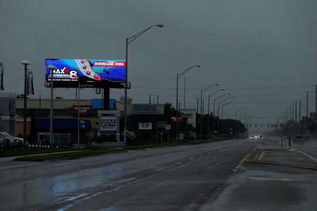 TAMPA, FL - SEPTEMBER 10: With the sky darkening and the wind picking up, the few remaining motorists on Dale Mabry Highway pass a billboard displaying the current track of Hurricane Irma on September 10, 2017 in Tampa, Florida. Hurricane Irma made landfall in the Florida Keys as a Category 4 storm on Sunday, lashing the state with 130 mph winds as it moves up the coast.   Brian Blanco/Getty Images/AFP