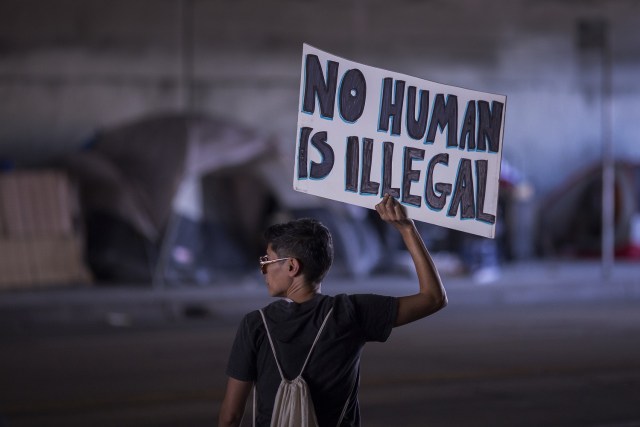 LOS ANGELES, CA - SEPTEMBER 10: A marcher passes the tents of homeless people at an encampment in an underpass as thousands of immigrants and supporters join the Defend DACA March to oppose the President Trump order to end DACA on September 10, 2017 in Los Angeles, California. The Obama-era Deferred Action for Childhood Arrivals program provides undocumented people who arrived to the US as children temporary legal immigration status for protection from deportation to a country many have not known, and a work permit for a renewable two-year period. The order exposes about 800,000 so-called ÒdreamersÓ who signed up for DACA to deportation. About a quarter of them live in California. Congress has the option to replace the policy with legislation before DACA expires on March 5, 2018.   David McNew/Getty Images/AFP
