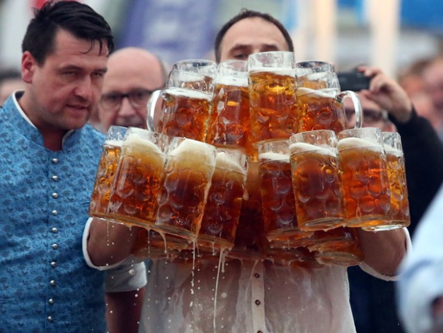 German Oliver Struempfel competes to set a new world record in carrying one liter beer mugs over a distance of 40 m (131 ft 3 in) in Abensberg, Germany September 3, 2017. Struempfel carried 29 mugs over 40 meters to set a new world record. REUTERS/Michael Dalder
