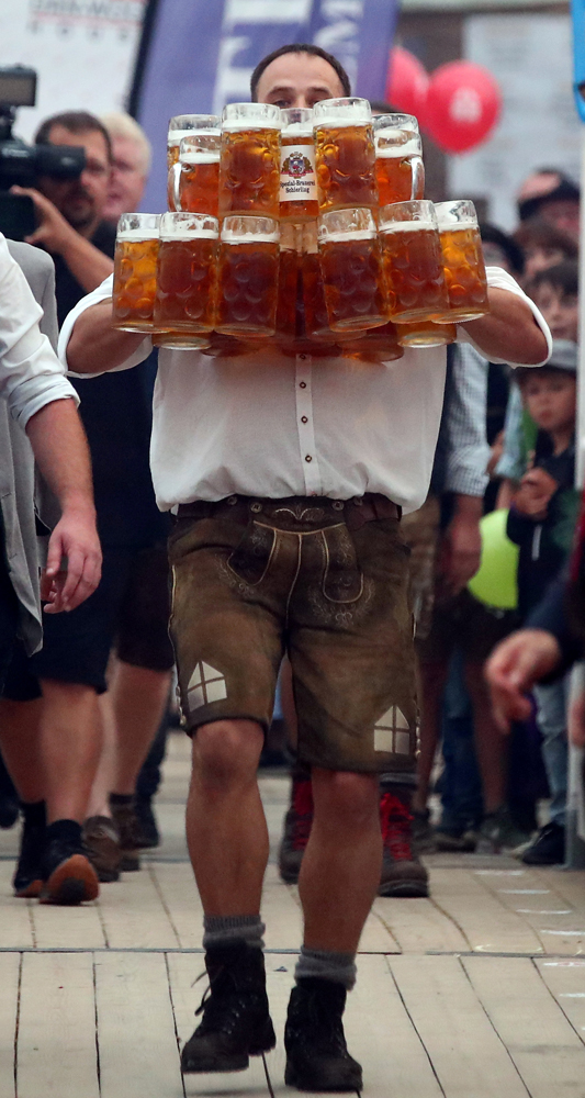 German Oliver Struempfel competes to set a new world record in carrying one liter beer mugs over a distance of 40 m (131 ft 3 in) in Abensberg, Germany September 3, 2017. Struempfel carried 27 mugs over 40 meters to set a new world record. REUTERS/Michael Dalder