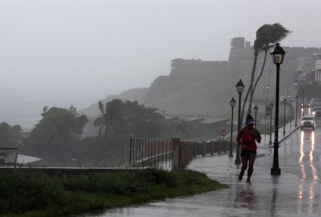A woman runs in the rain as Hurricane Irma slammed across islands in the northern Caribbean on Wednesday, in San Juan, Puerto Rico September 6, 2017.  REUTERS/Alvin Baez