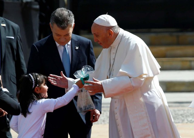 Colombia's President Juan Manuel Santos (C) looks on as Pope Francis is greeted by a girl during a meeting at Narino presidential palace in Bogota, Colombia September 7, 2017. REUTERS/Stefano Rellandini