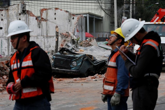 Unas personas trabajando cerca de un muro y un vehículo dañados tras un sismo en Ciudad de México, sep 8, 2017. REUTERS/Carlos Jasso
