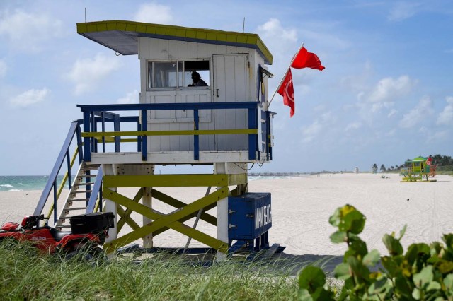 A lifeguard in beach patrol tower keeps watch along a stretch of the beach in Miami Beach, Florida, U.S., September 8, 2017. REUTERS/Bryan Woolston