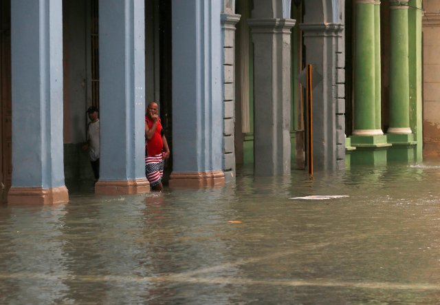 A man leans on a pillar in a flooded street after the passing of Hurricane Irma, in Havana, Cuba, September 10, 2017. REUTERS/Stringer NO SALES. NO ARCHIVES