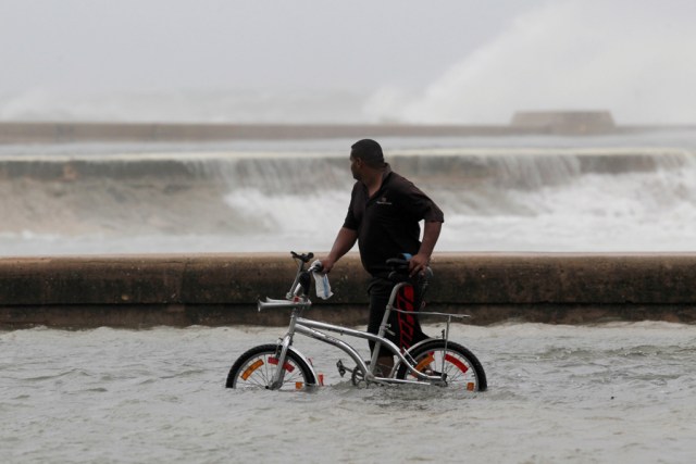 A man pushes his bike through a flooded street after the passing of Hurricane Irma, in Havana, Cuba, September 10, 2017. REUTERS/Stringer NO SALES. NO ARCHIVES