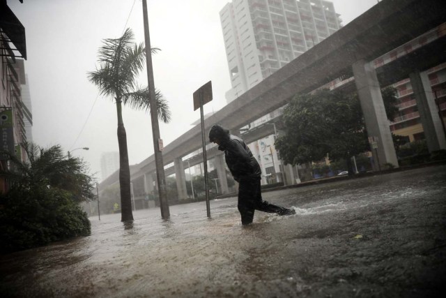 A local resident walks across a flooded street in downtown Miami as Hurricane Irma arrives at south Florida, U.S. September 10, 2017. REUTERS/Carlos Barria