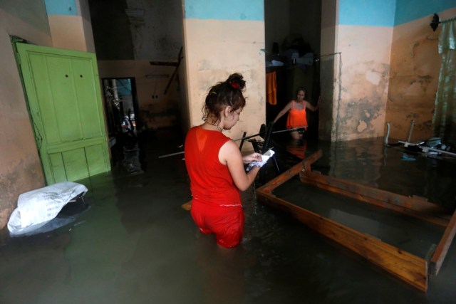 A woman looks at wet papers in her flooded home, after the passing of Hurricane Irma, in Havana, Cuba September 10, 2017. REUTERS/Stringer NO SALES. NO ARCHIVES