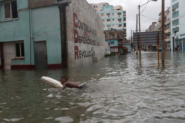 A boy floats with a foam board in a flooded street, after the passing of Hurricane Irma, in Havana, Cuba September 10, 2017. REUTERS/Stringer NO SALES. NO ARCHIVES