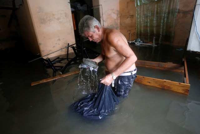 A man picks up spoiled things in his flooded home, after  the passing of Hurricane Irma, in Havana, Cuba September 10, 2017. REUTERS/Stringer NO SALES. NO ARCHIVES