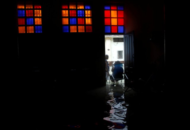 A woman talks to a neighbour while sitting in the door of her flooded home, after the passing of Hurricane Irma, in Havana, Cuba September 10, 2017. REUTERS/Stringer NO SALES. NO ARCHIVES