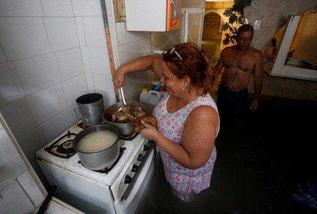 A woman cooks in her flooded home, after the passing of Hurricane Irma, in Havana, Cuba September 10, 2017. REUTERS/Stringer NO SALES. NO ARCHIVES