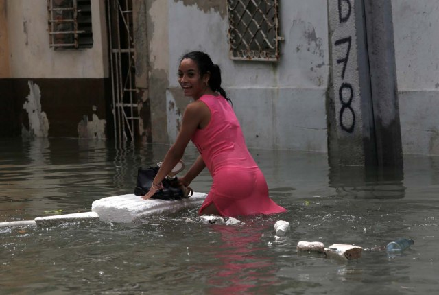 A woman keeps her shoes dry on a piece of foam board while wading through a flooded street, after the passing of Hurricane Irma, in Havana, Cuba September 10, 2017. REUTERS/Stringer NO SALES. NO ARCHIVES TPX IMAGES OF THE DAY