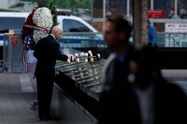 A man places white roses at the edge of the South reflecting pool at the National September 11 Memorial and Museum during ceremonies marking the 16th anniversary of the September 11, 2001 attacks in New York, U.S, September 11, 2017. REUTERS/Brendan McDermid