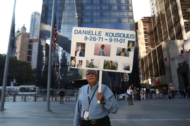 George Kousoulis holds a sign with images of his late daughter Danielle Kousoulis who was killed in the September 11, 2001 attacks in New York near the National September 11 Memorial and Museum on the 16th anniversary of the attacks in New York, U.S. September 11, 2017. REUTERS/Shannon Stapleton