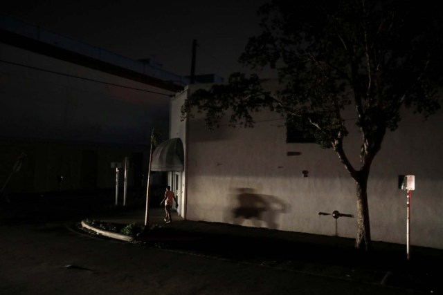 A man walks in the darkness as many areas of Miami still without electricity after Hurricane Irma strikes Florida, in Little Havana, Miami, Florida, September 11, 2017. REUTERS/Carlos Barria