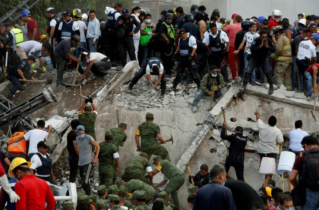 Soldiers, rescuers and people work at a collapsed building after an earthquake in Mexico City, Mexico September 19, 2017. REUTERS/Ginnette Riquelme