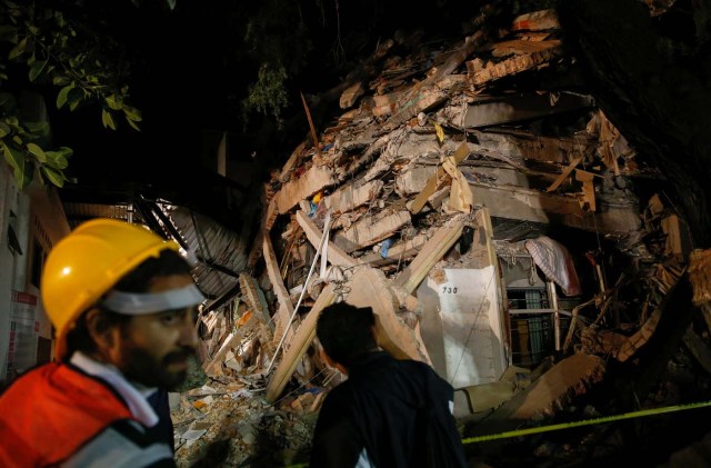A rescuer walks past at a collapsed building after an earthquake in Mexico City, Mexico September 20, 2017. REUTERS/Henry Romero
