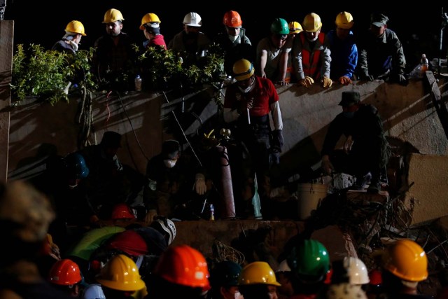 Rescue workers search through rubble in a floodlit search for students at Enrique Rebsamen school in Mexico City, Mexico September 20, 2017. REUTERS/Carlos Jasso