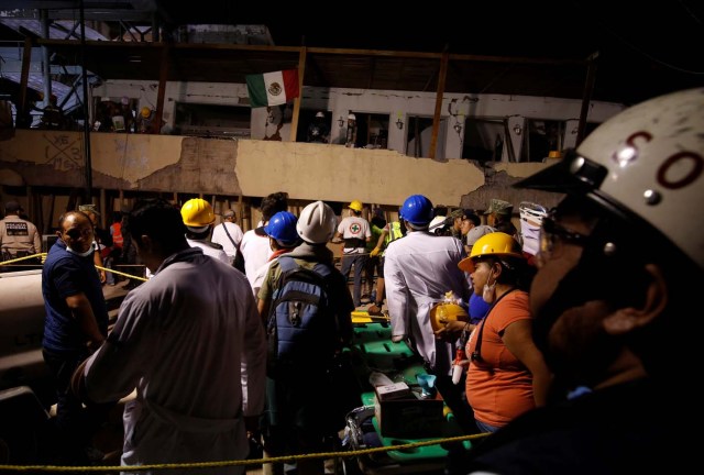 Rescue workers search through rubble in a floodlit search for students at Enrique Rebsamen school in Mexico City, Mexico September 19, 2017. Picture taken on September 19, 2017. REUTERS/Carlos Jasso