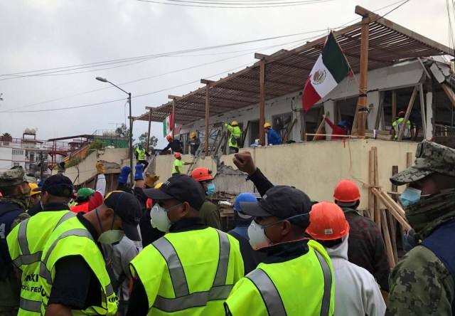 Soldados y socorristas piden silencio a la gente alrededor de la escuela Enrique Rébsamen en Ciudad de México, mientras tratan de encontrar a estudiantes entre los escombros. 20 de septiembre de 2017  REUTERS/Michael O'Boyle