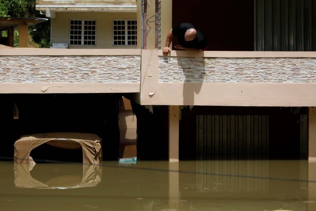 A man looks at damages on his flooded house, close to the dam of the Guajataca lake after the area was hit by Hurricane Maria in Guajataca, Puerto Rico September 23, 2017. REUTERS/Carlos Garcia Rawlins