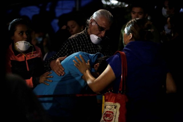 People comfort a family member of an earthquake victim who is still trapped in the rubble of a collapsed building, after an earthquake in Mexico City, Mexico September 23, 2017. Picture taken September 23, 2017. REUTERS/Jose Luis Gonzalez