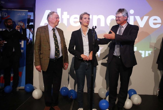 Joerg Meuthen (R), leader of the anti-immigration party Alternative fuer Deutschland (AfD) reacts next to top candidates Alice Weidel and Alexander Gauland (L) after first exit polls in the German general election (Bundestagswahl) in Berlin, Germany, September 24, 2017. REUTERS/Wolfgang Rattay