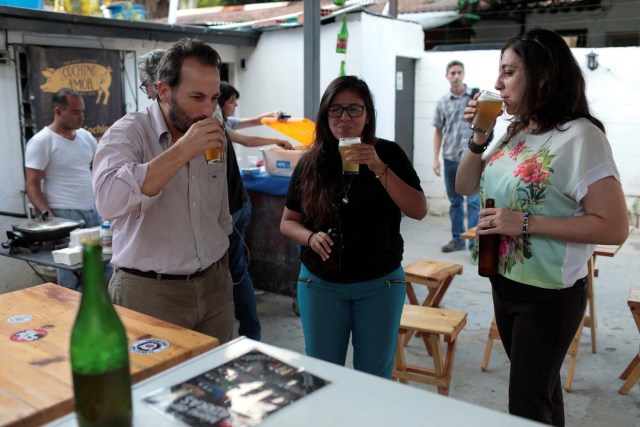 People drink craft beer in a beer garden at the garage of Social Club brewery in Caracas, Venezuela, September 15, 2017. Picture taken September 15, 2017. REUTERS/Marco Bello