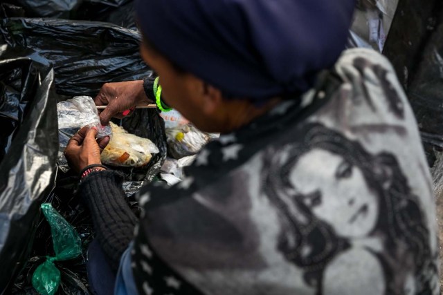 ACOMPAÑA CRÓNICA: VENEZUELA CRISIS. CAR07. CARACAS (VENEZUELA), 25/09/2017.- Fotografía fechada el 20 de septiembre de 2017 que muestra a una mujer mientras hurga en una basura en busca de comida en una calle de Caracas (Venezuela). En las calles de Caracas deambulan cada vez más niños y de menos edad. Se trata, según analistas y activistas de derechos humanos, de una nueva oleada de pequeños que prácticamente han abandonado sus hogares, aunque esta vez la razón es una sola: "La falta de comida en sus casas". EFE/Miguel Gutiérrez
