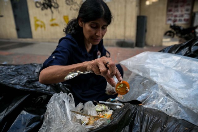ACOMPAÑA CRÓNICA: VENEZUELA CRISIS. CAR03. CARACAS (VENEZUELA), 25/09/2017.- Fotografía fechada el 20 de septiembre de 2017 que muestra a una mujer mientras hurga en una basura en busca de comida en una calle de Caracas (Venezuela). En las calles de Caracas deambulan cada vez más niños y de menos edad. Se trata, según analistas y activistas de derechos humanos, de una nueva oleada de pequeños que prácticamente han abandonado sus hogares, aunque esta vez la razón es una sola: "La falta de comida en sus casas". EFE/Miguel Gutiérrez