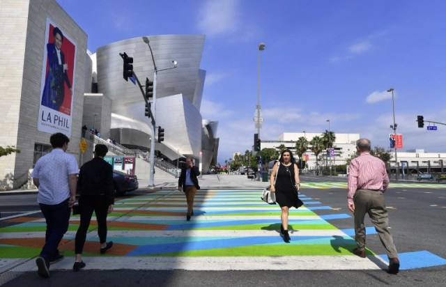 Pedestrians cross a painted sidewalk by Venezuelan-born artist Carlos Cruz-Diez outside the Broad Museum in Los Angeles, California on September 14, 2017, where the painted crosswalks are a part of the Pacific Standard Time LA/LA Show, an exploration of Latino and Latin American Art in dialogue with Los Angeles.  / AFP PHOTO / FREDERIC J. BROWN