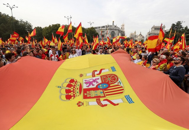 Manifestantes sostienen banderas españolas en una marcha a favor de la unidad del país y en contra de un referéndum catalán prohibido por la Justicia, en Madrid, España, September 30, 2017. REUTERS/Sergio Perez