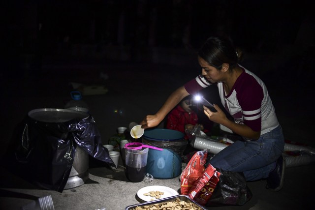 A woman prepares coffee in a square after a powerful quake hit Mexico City, late on September 19, 2017. The death toll from a powerful earthquake that rocked Mexico on September 19 has surged to 248 people, the head of the national disaster response agency, Luis Felipe Puente, said on Twitter. / AFP PHOTO / RONALDO SCHEMIDT