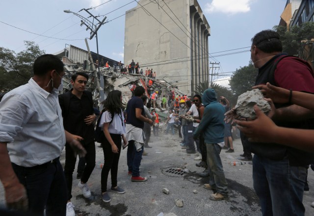 People help to remove rubble from a collapsed building after an earthquake hit Mexico City, Mexico September 19, 2017. REUTERS/Claudia Daut