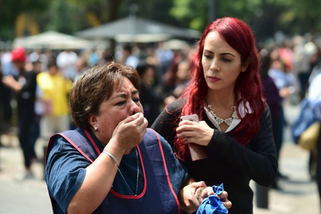 A woman reacts as a real quake rattles Mexico City on September 19, 2017 as an earthquake drill was being held in the capital. / AFP PHOTO / Ronaldo SCHEMIDT