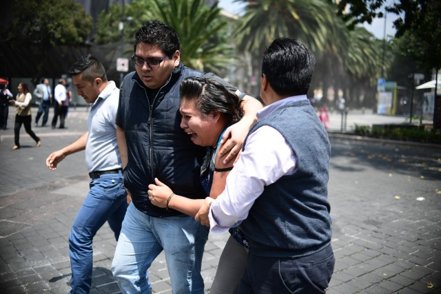 People react as a real quake rattles Mexico City on September 19, 2017 moments after an earthquake drill was held in the capital. A 7.1 magnitude earthquake shook Mexico City on Tuesday, destroying buildings and causing an unknown number of casualties on the anniversary of a devastating 1985 quake. The quake sowed panic in the sprawling city of 20 million people, many of whom have memories of the quake 32 years ago that killed some 10,000 people in Mexico City.  / AFP PHOTO / Ronaldo SCHEMIDT
