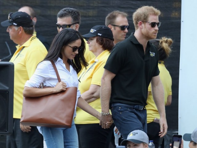 TORONTO, ON - SEPTEMBER 25: Prince Harry and Meghan Markle hold hands a Wheelchair Tennis match during the Invictus Games 2017 at Nathan Philips Square on September 25, 2017 in Toronto, Canada   Chris Jackson/Getty Images for the Invictus Games Foundation /AFP