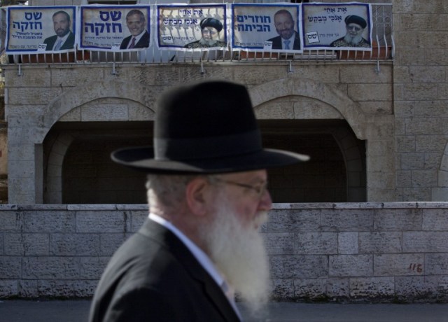 Elecciones en Israel Un judío ultraortodoxo camina frente a una casa decorada con carteles. (Jim Hollander / EFE) 