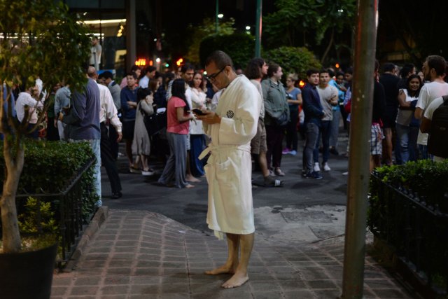 Un grupo de personas se reunen en el centro de la Ciudad de México en los momentos posteriores al terremoto. (AFP PHOTO / Luis PEREZ)