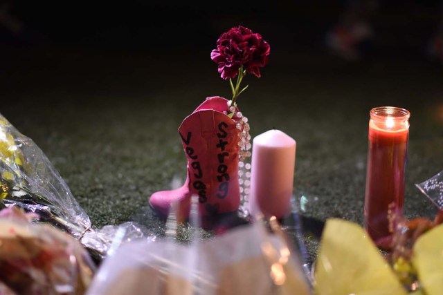 Flowers are placed into a pink boot at a makeshift memorial are seen near the Mandalay Hotel on the Las Vegas Strip, in Las Vegas, Nevada on October 3, 2017, after a gunman killed 58 people and wounded more than 500 others, before taking his own life, when he opened fire from a hotel on a country music festival. Police said the gunman, a 64-year-old local resident named as Stephen Paddock, had been killed after a SWAT team responded to reports of multiple gunfire from the 32nd floor of the Mandalay Bay, a hotel-casino next to the concert venue. / AFP PHOTO / Robyn Beck