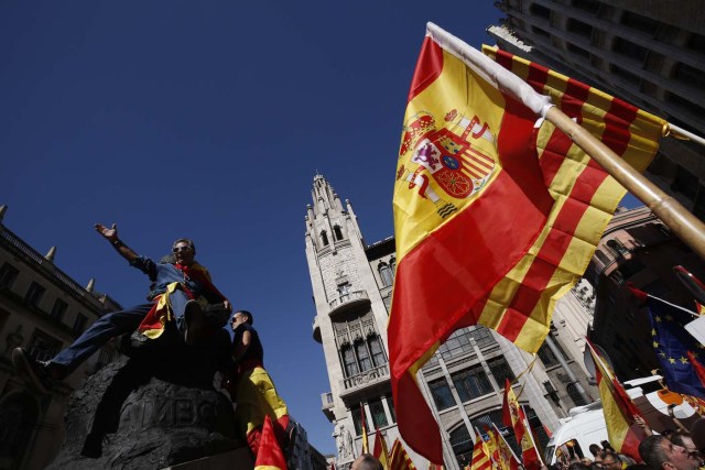 Protesters hold Spanish flags during a demonstration called by "Societat Civil Catalana" (Catalan Civil Society) to support the unity of Spain on October 8, 2017 in Barcelona. Spain braced for more protests despite tentative signs that the sides may be seeking to defuse the crisis after Madrid offered a first apology to Catalans injured by police during their outlawed independence vote. / AFP PHOTO / PAU BARRENA