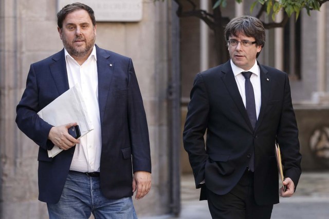 Catalan regional government president Carles Puigdemont (R) and Catalan regional vice president and chief of economy and finance Oriol Junqueras arrive for a regional government meeting at the Generalitat Palace in Barcelona on October 10, 2017. Spain's worst political crisis in a generation will come to a head as Catalonia's leader could declare independence from Madrid in a move likely to send shockwaves through Europe. / AFP PHOTO / PAU BARRENA