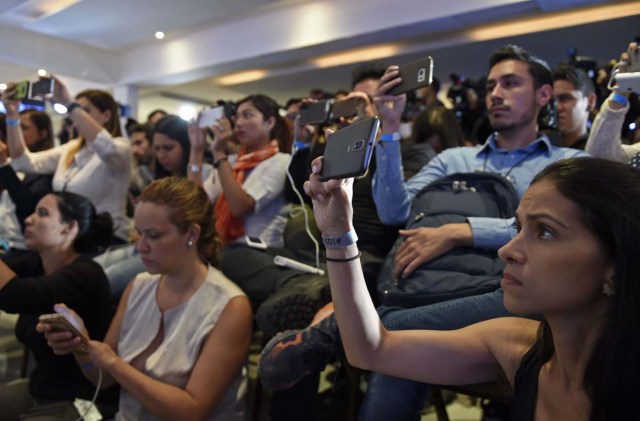 Venezuelan opposition supporters and members of the media gather at the Democratic Unity Roundtable (MUD) headquarters to wait for the results of the regional elections in Caracas on October 15, 2017. The socialist government of President Nicolas Maduro won a landslide 17 out of 23 states in Venezuela's regional elections Sunday, according to official results announced by the National Elections Council. The opposition Democratic Union Roundtable (MUD) coalition, which earlier said the upcoming results were "suspicious", took only five of the states, according to the results. / AFP PHOTO / JUAN BARRETO