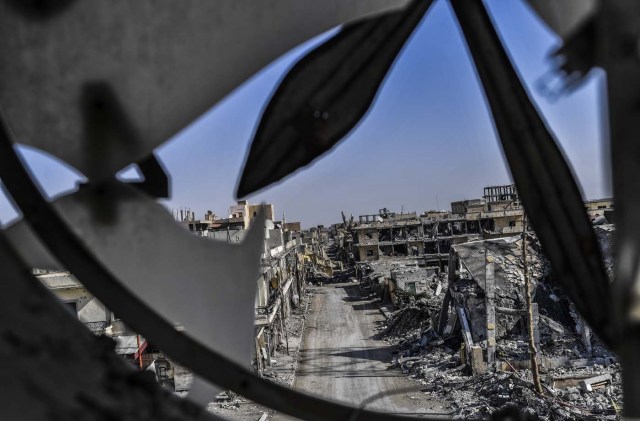 A picture taken from Raqa's clock tower shows heavily damaged buildings on October 21, 2017, after a Kurdish-led force expelled Islamic State (IS) group fighters from the northern Syrian city. The US-backed Syrian Democratic Forces officially announced Raqa's capture at a ceremony in the city's stadium on October 20 but said mines left behind by IS made it too dangerous for residents to return home. / AFP PHOTO / BULENT KILIC
